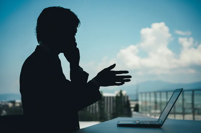 Silhouette of a person with a laptop